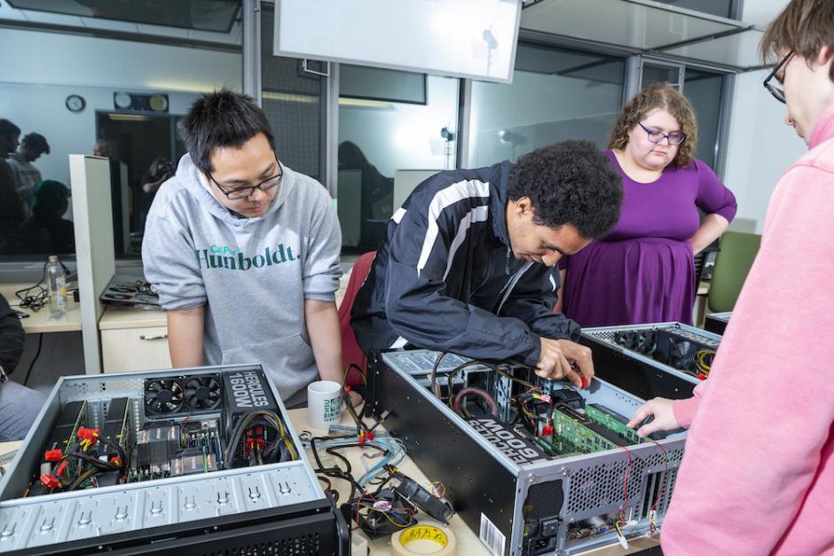three students working on a supercomputer 