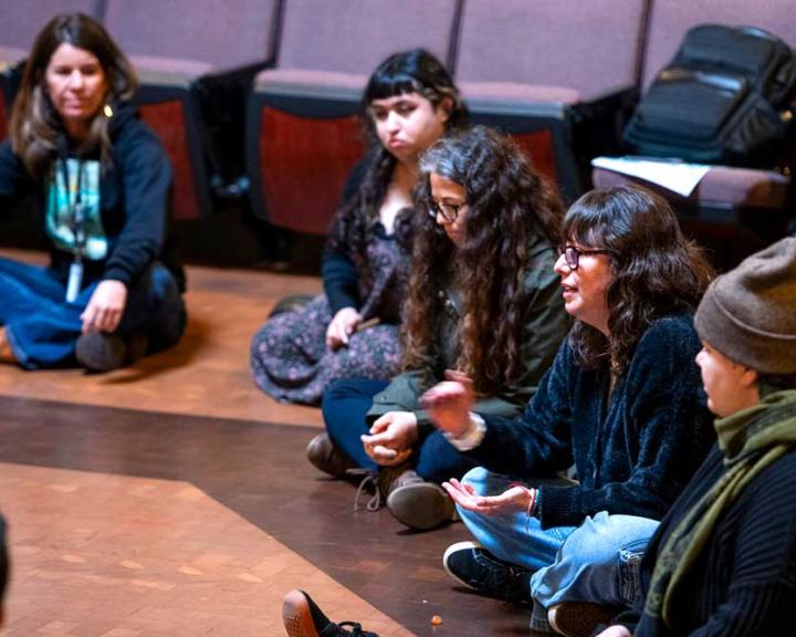 Group of people sitting on the floor in a circle