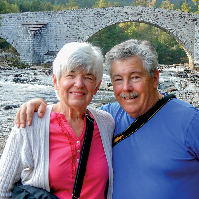 Jack and Diana posing together under a bridge next to a river