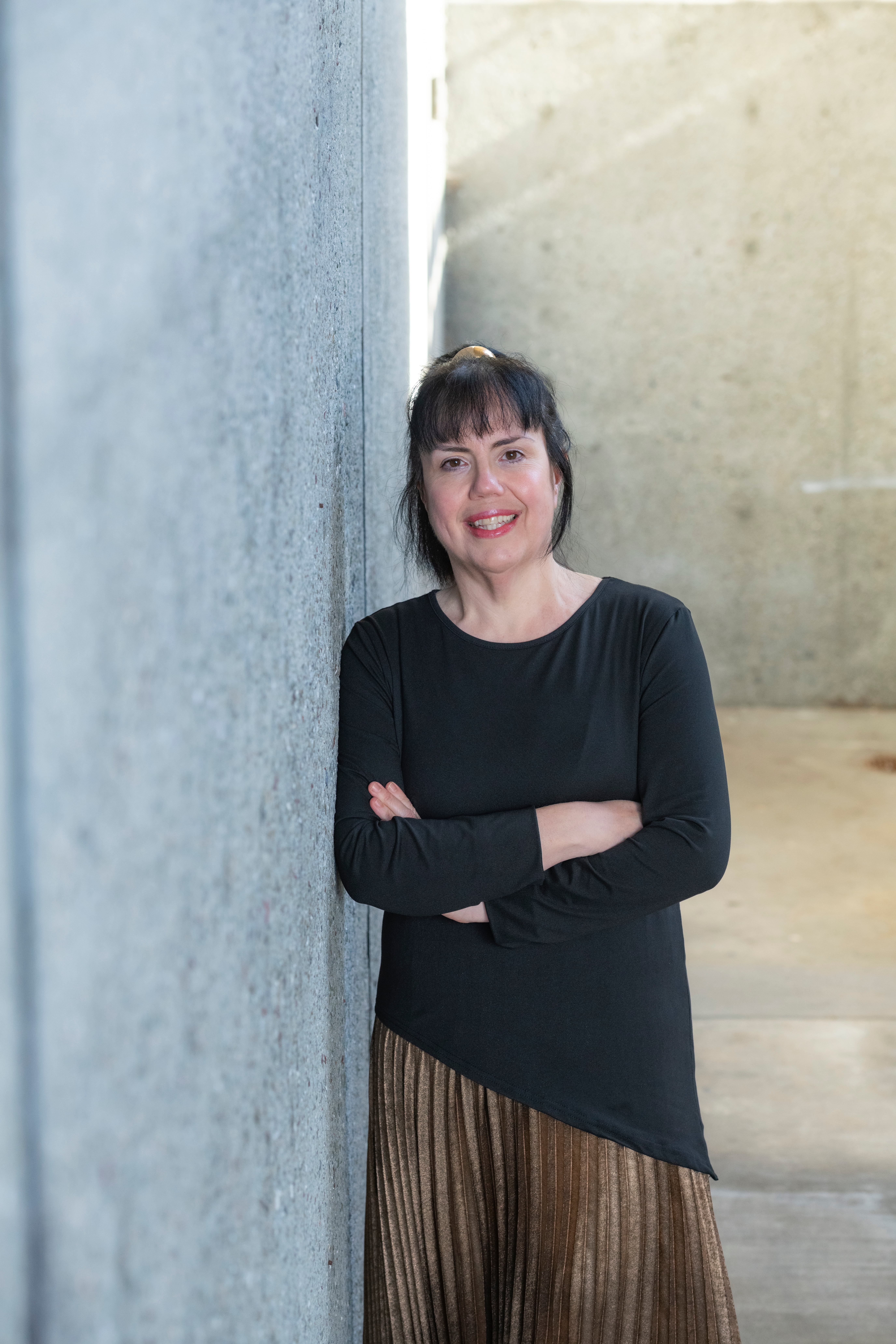 Dr. Mineva leaning against a concrete wall