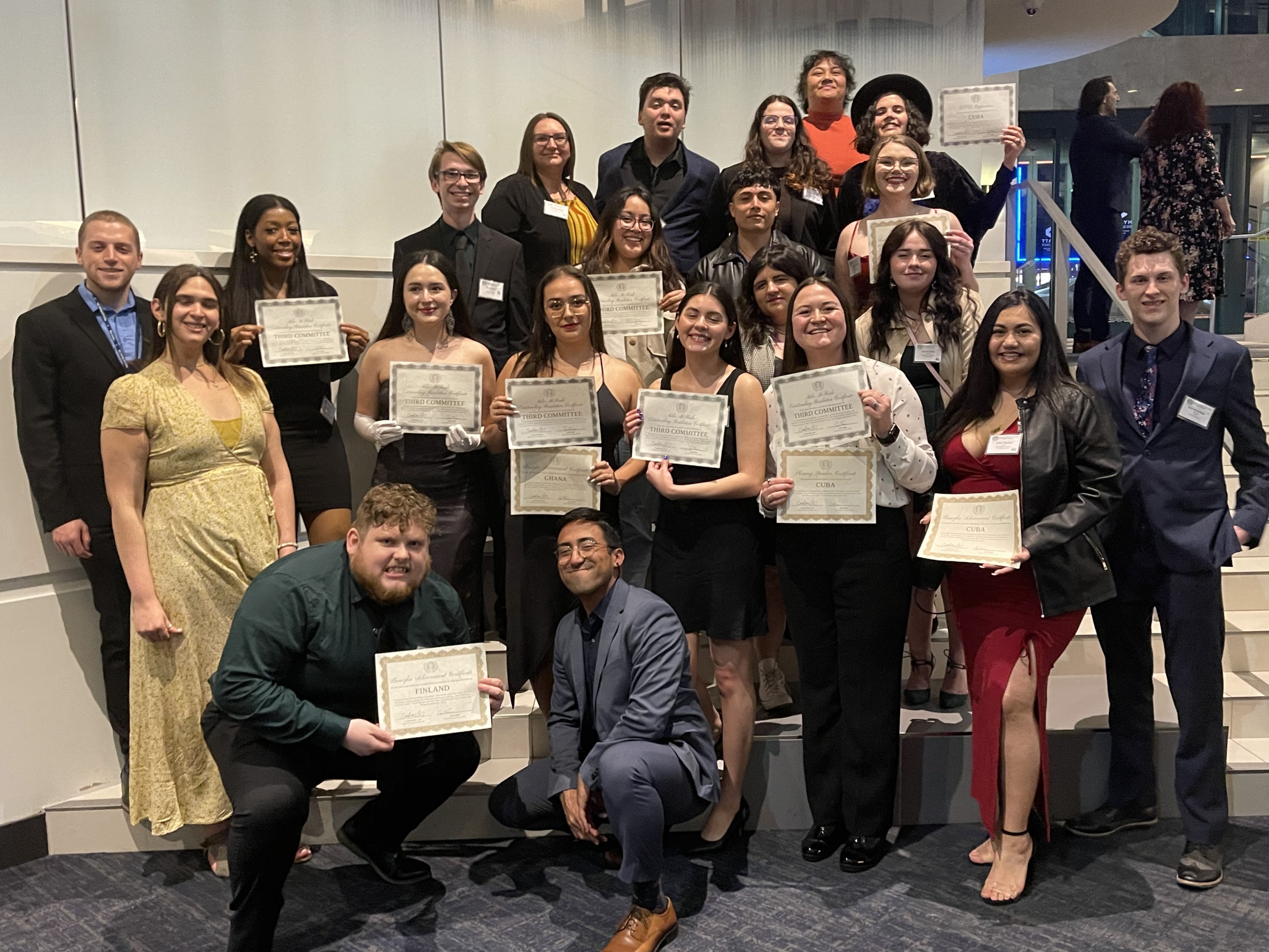 students in a group holding certificates and smiling for the camera