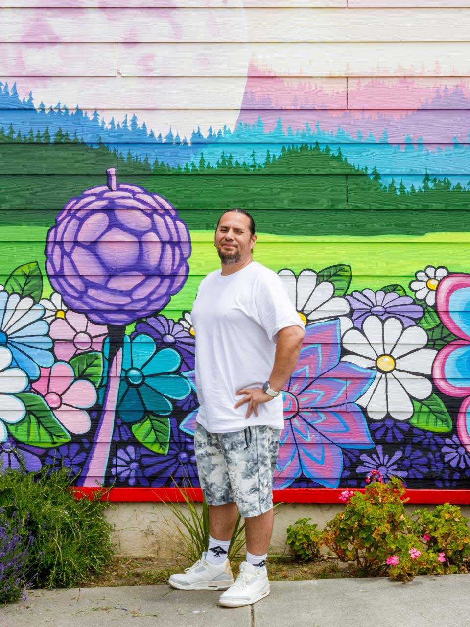 Pliny McCovey standing in front of a mural
