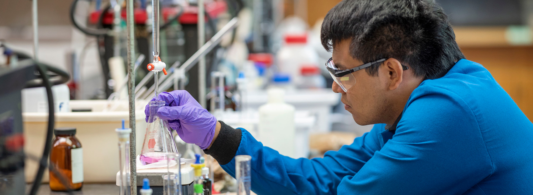 Man in lab coat in front burner