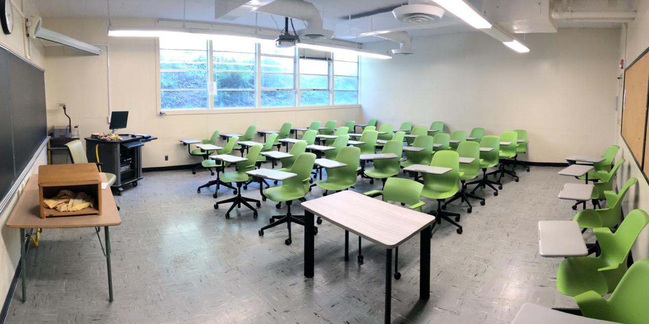 Art A 27 Classroom - Room with green swivel chair desks facing a blackboard