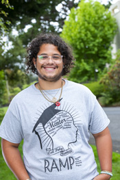 Ezra smiling for the camera wearing a ramp shirt standing outside