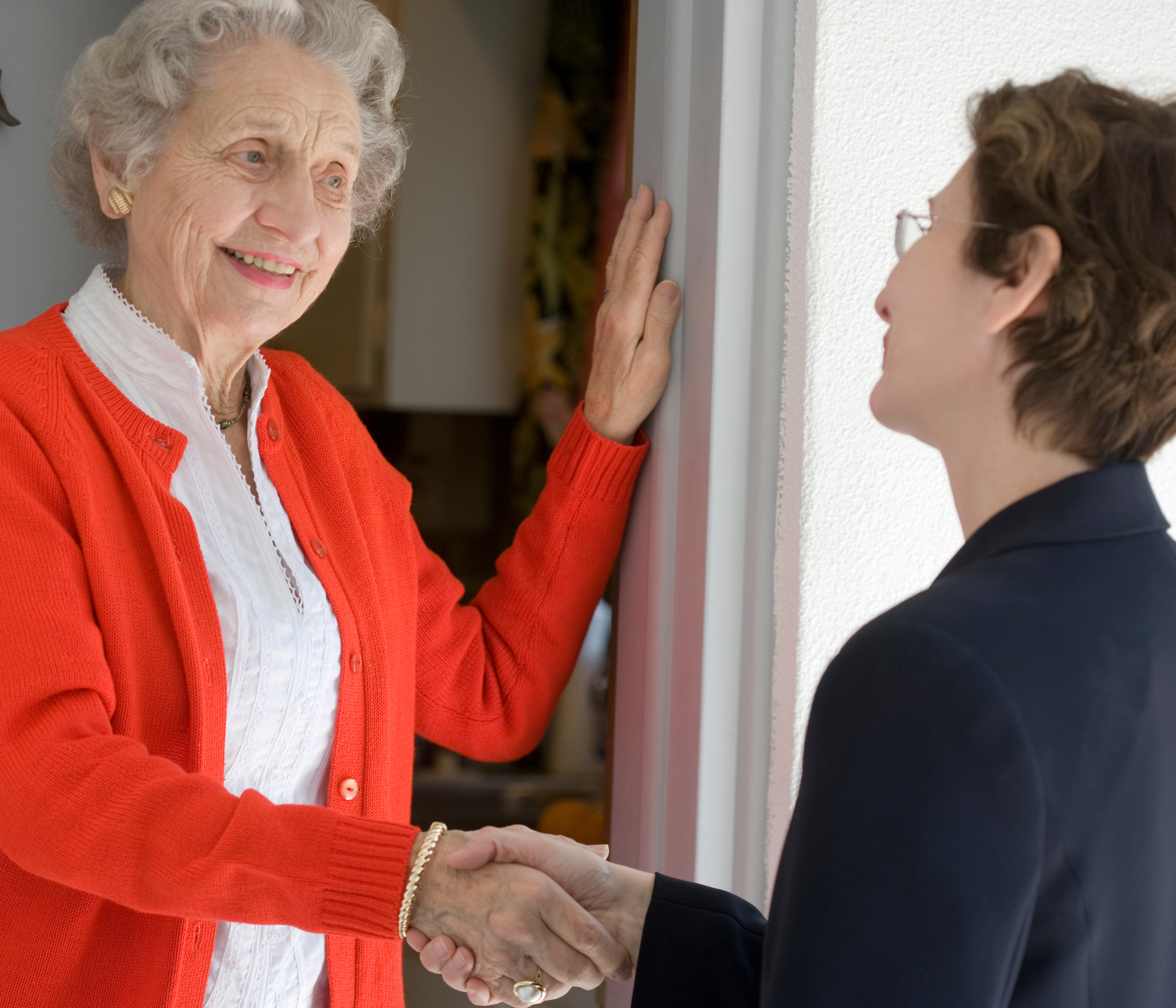 Older woman shaking hands with younger woman