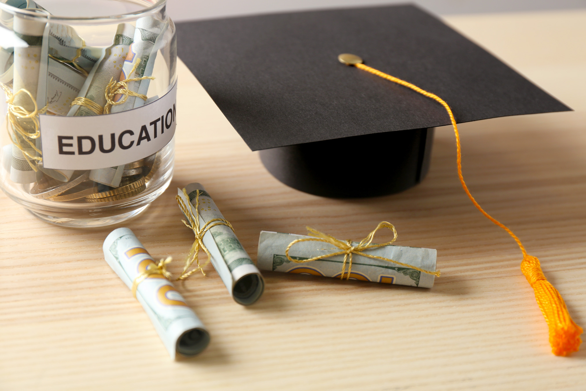 money in a jar marked 'education' and mortarboard