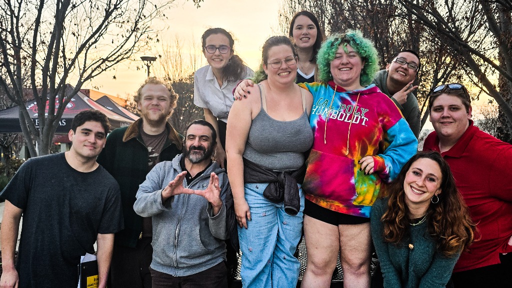 A group of 10 debate club members smiling.