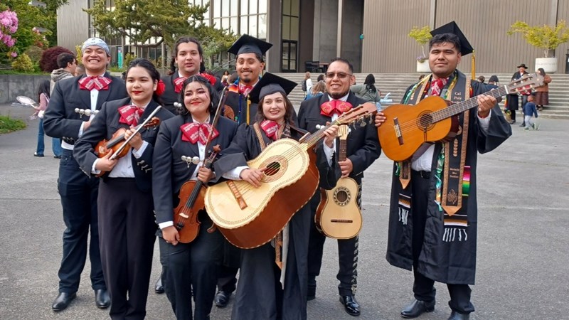 The Humboldt Mariachi band club members with instruments in uniform and graduation regalia.