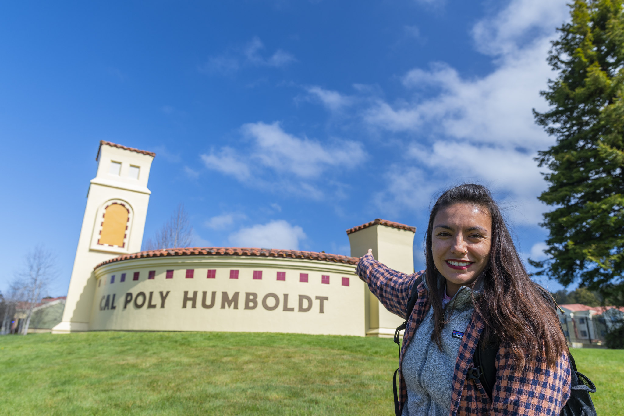 Student pointing at the Cal Poly Humboldt Sign