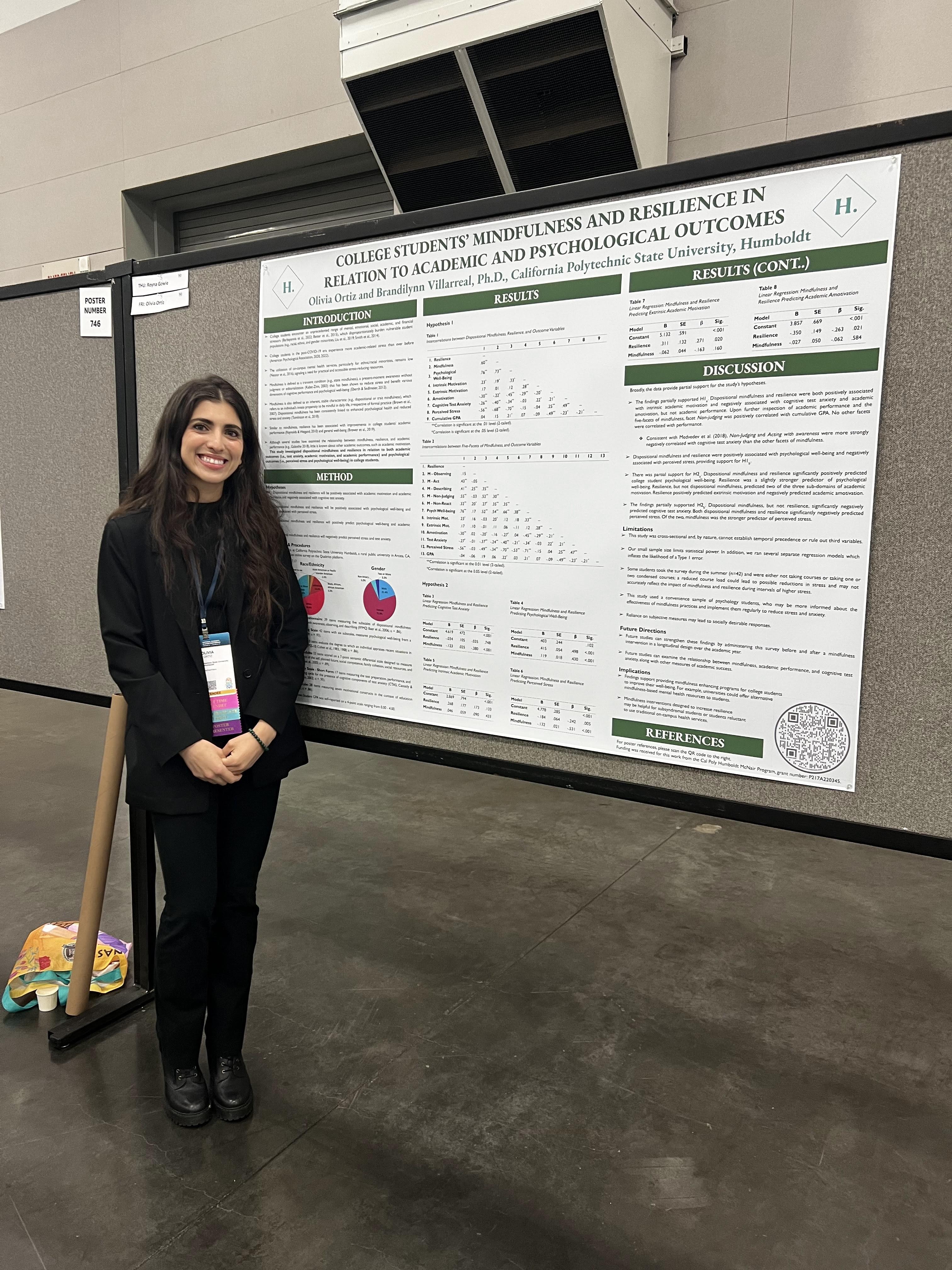 student standing in front and to the left of a big poster