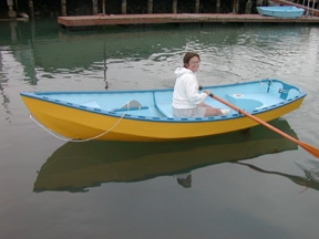 joan on the water in a light blue boat with a yellow bottom 