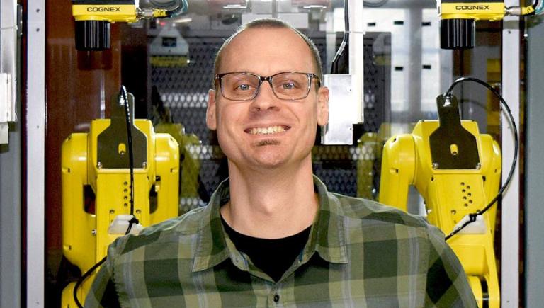 A white man with glasses and a plaid shirt