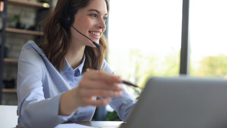 Woman wearing a headset, while working on computer