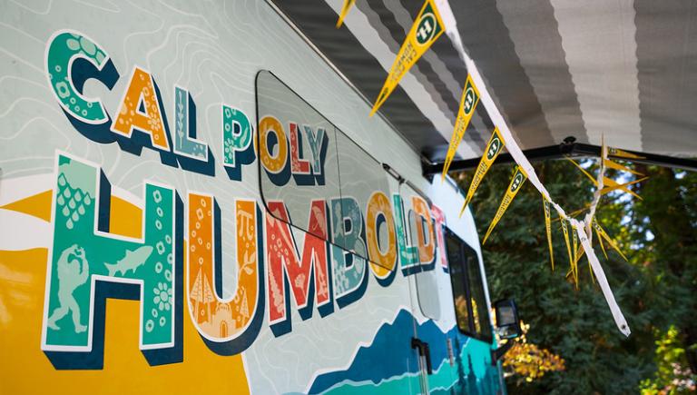A side view of a cal pol humboldt logo on the mobile alumni center.