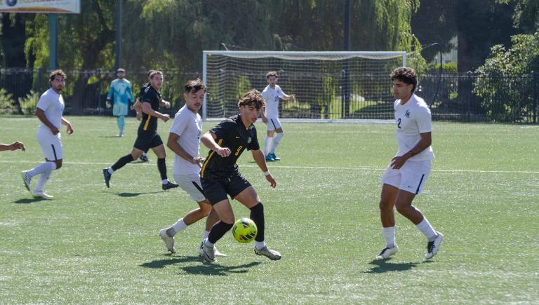 Humboldt men's soccer players in black uniforms competing against Cal State San Marcos players in white 