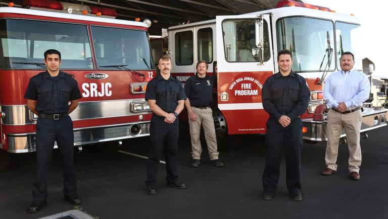 Firefighter staff and management in front of fire trucks