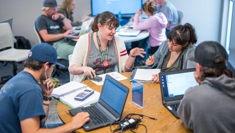 Photo of tutor working with group of students