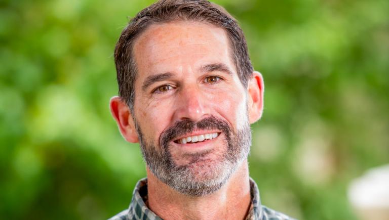 Justus' portrait with a green background outside