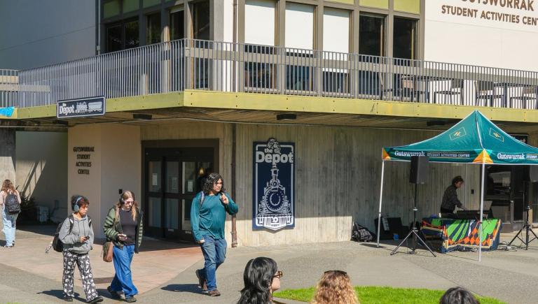 Students gather outside The Depot entrance at the Gutswurrak Student Activities Center.