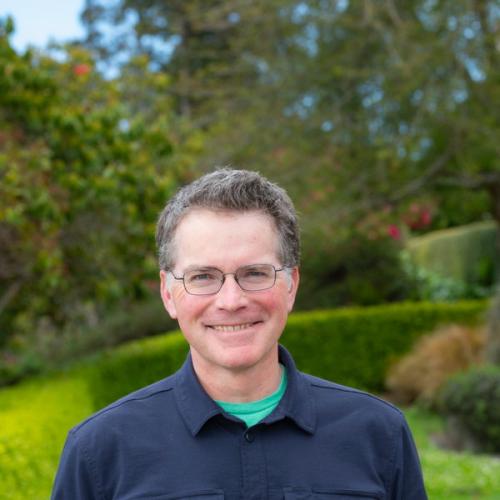 Brandon Browne portrait with campus greenery in background