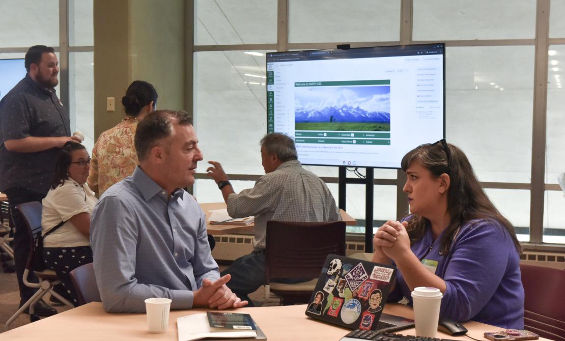 Two Instructors chatting during the Teaching Excellence Symposium