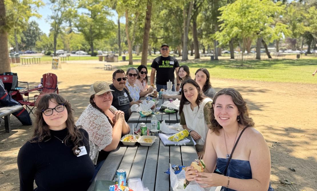 A group of parents and new Cal Poly Humboldt students at a picnic table.