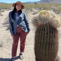 Person standing next to a large cactus