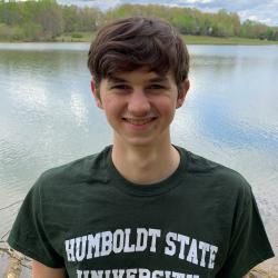 Locan out in the wilderness with a big lake in the background