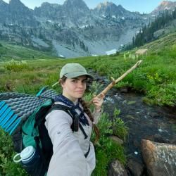 Jackie out in the wilderness with a bow and arrow