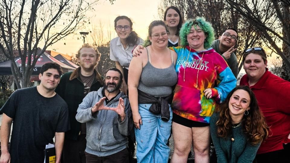 A group of 10 debate club members smiling.