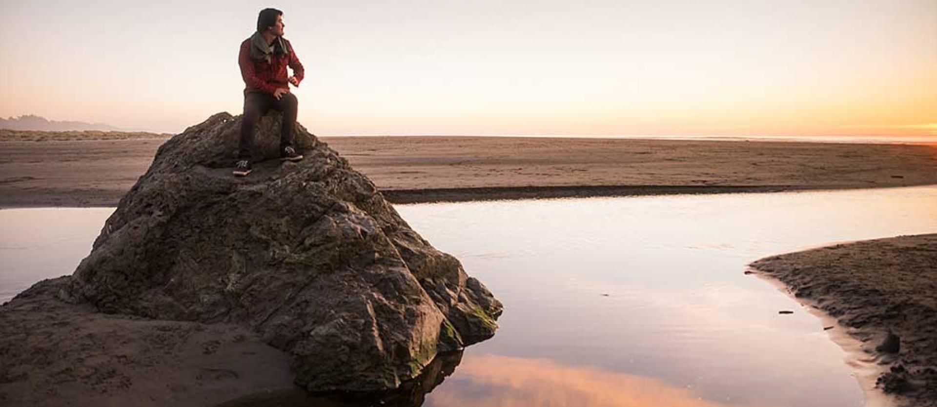 Enjoying the sunset from a rock in the little river at Moonstone Beach