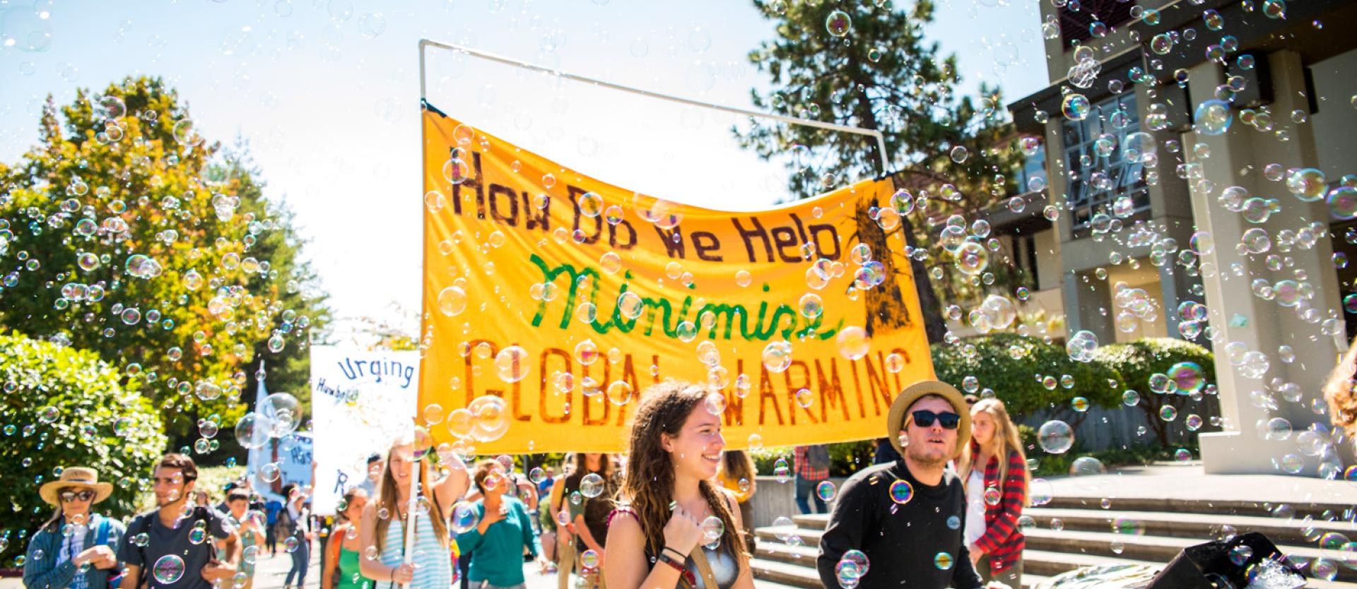 Students carrying a big yellow banner about global warming