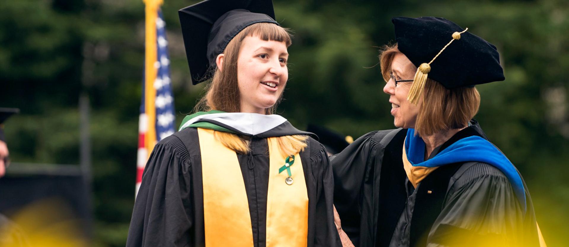 student and professor at graduation