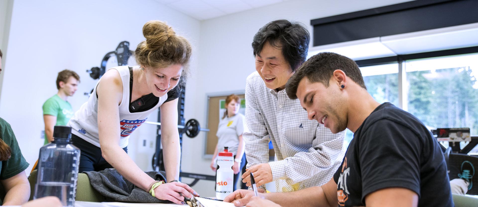 Three people around a desk taking notes 