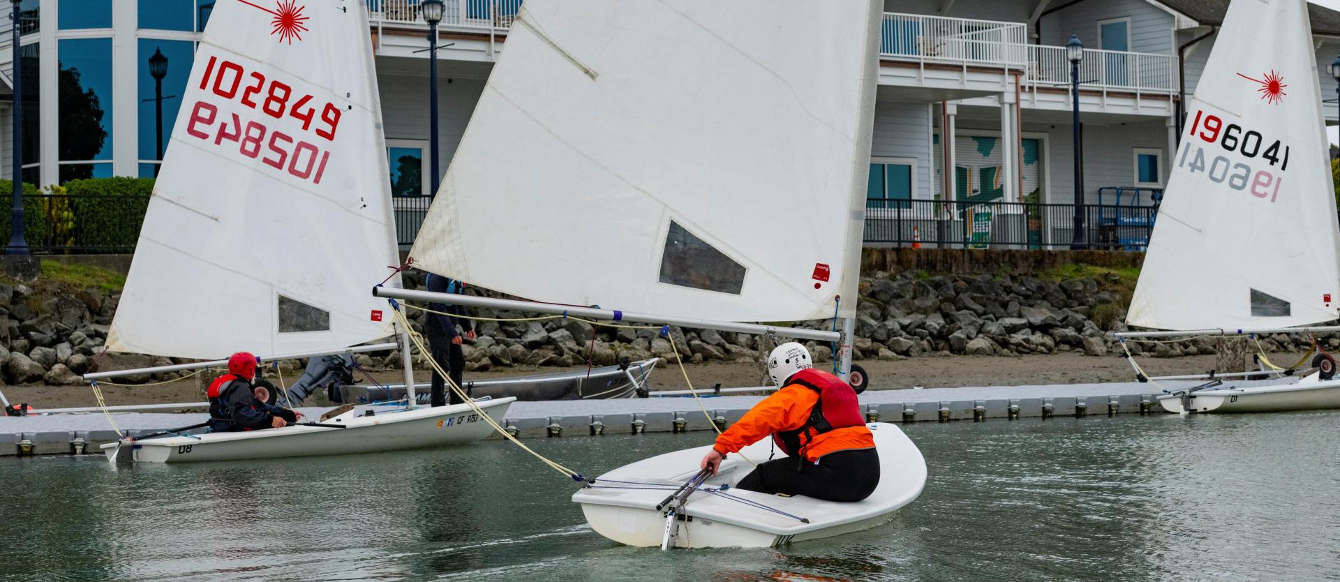 Student sailing in a small laser sailing dinghy.