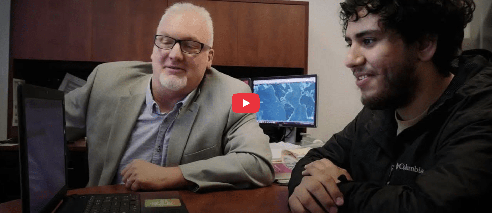 A video screenshot of two people at a computer