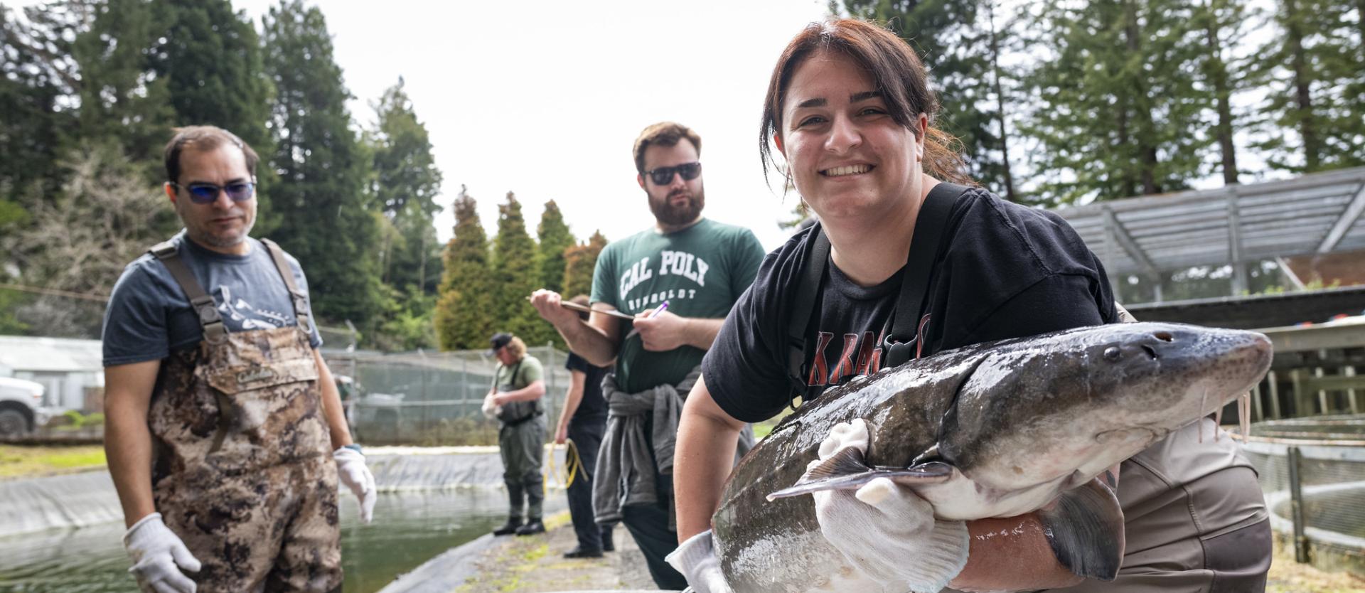 Student holds a sturgeon