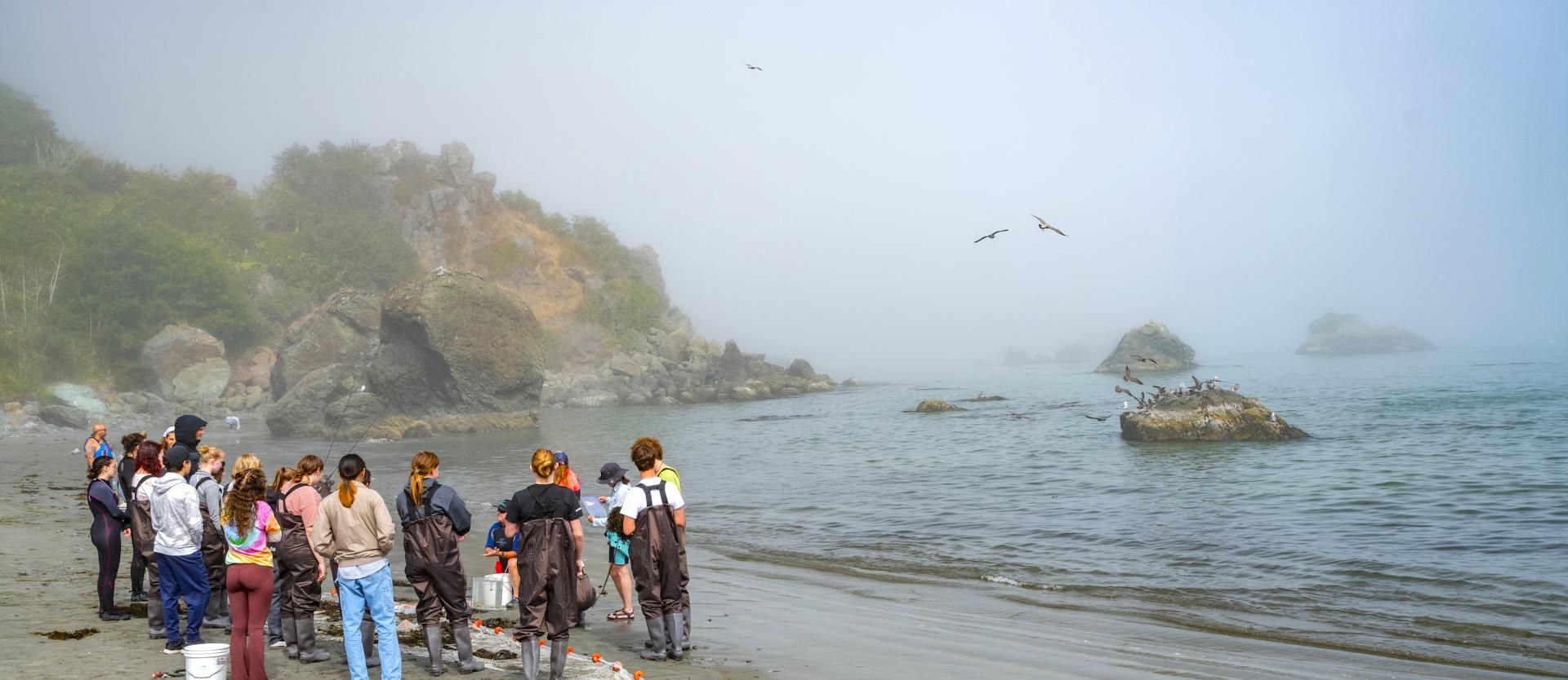 Students stand in a group on the beach in Trinidad.