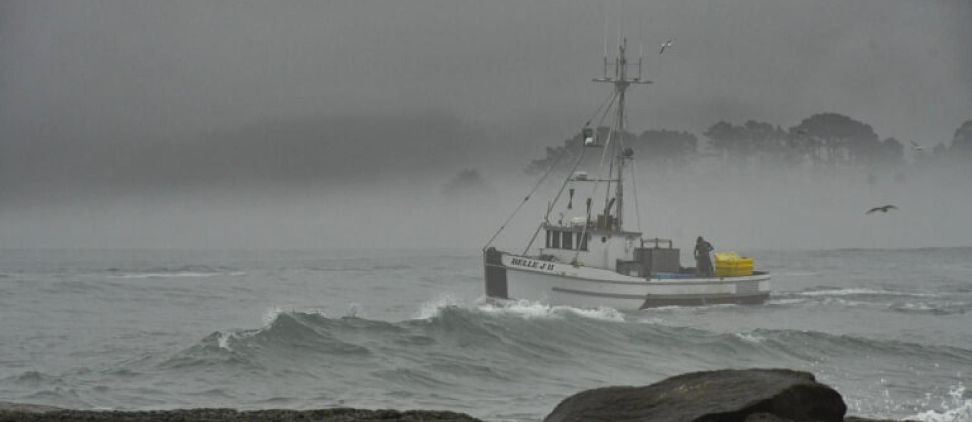 image of a boat going through rough waters on a stormy day