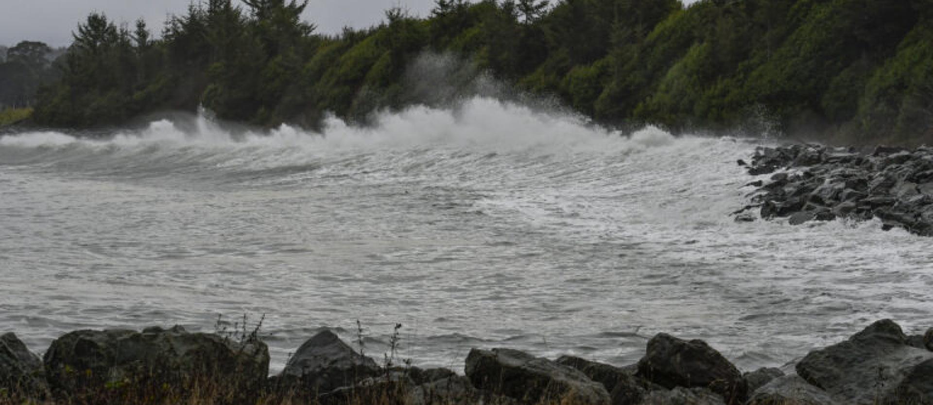 image of huge waves breaking dramatically on a rip rap rocky beach