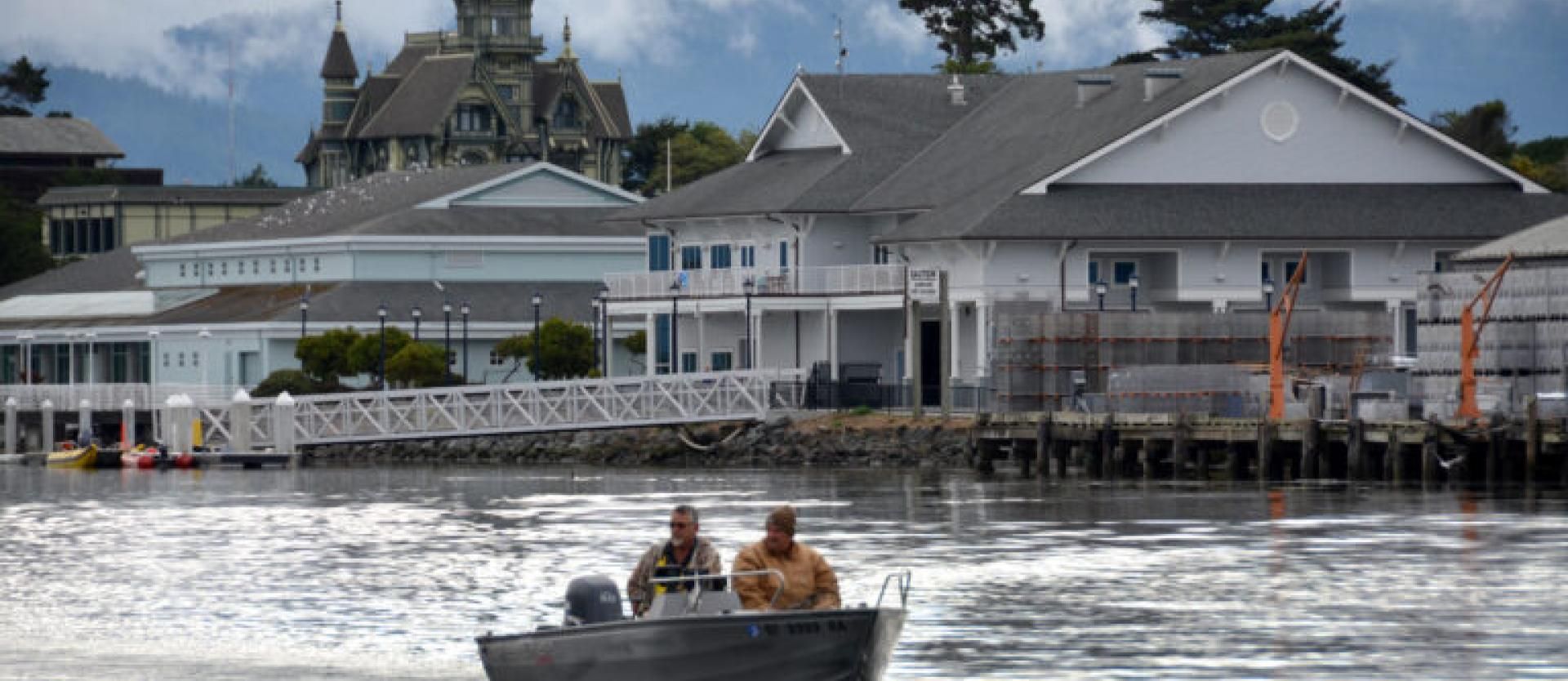 image of two people in a small motor boat along the Eureka waterfront