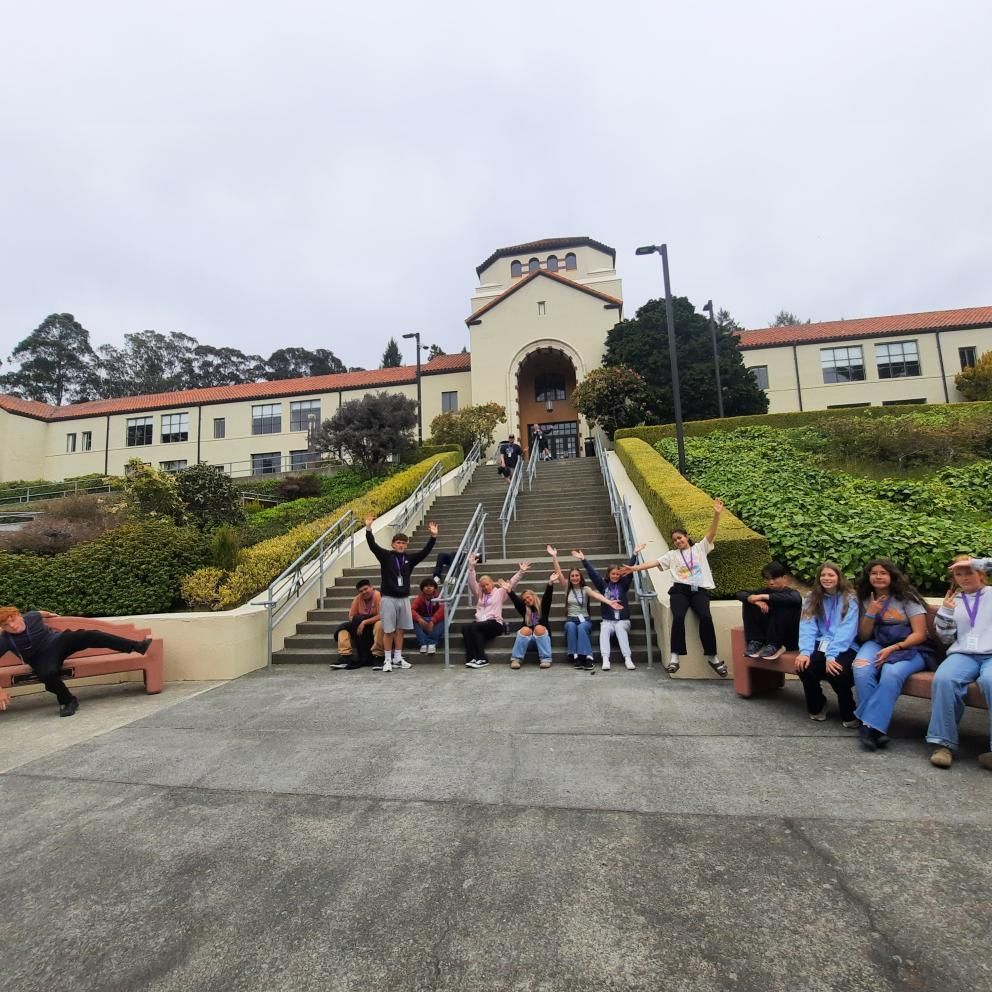 del norte students posing at the bottom of founders hall stairs