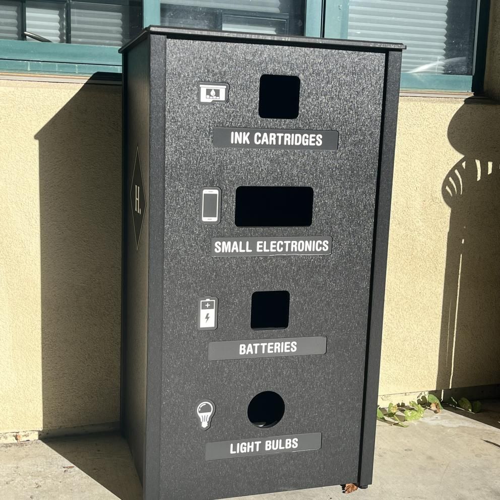 Image shows a recycling bin for universal and electronic waste, with four entry holes to place materials. 