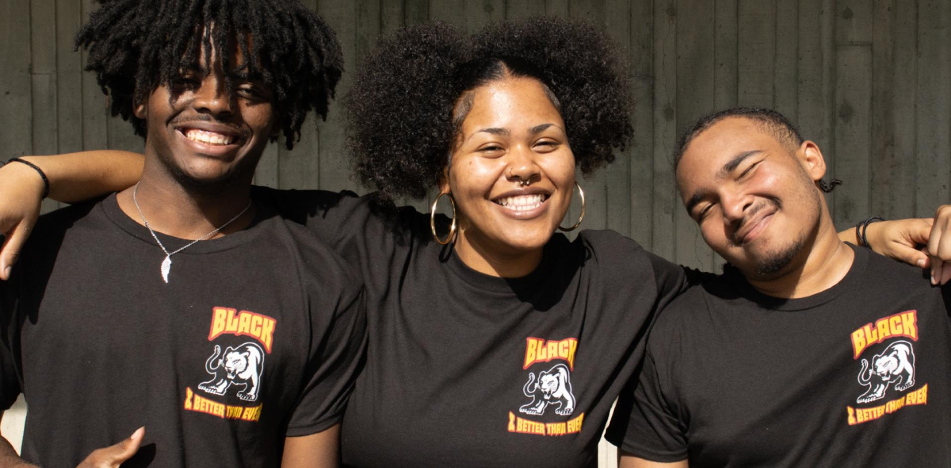 Three Umoja Student Staff smile for a photo in the SAC Lower Quad