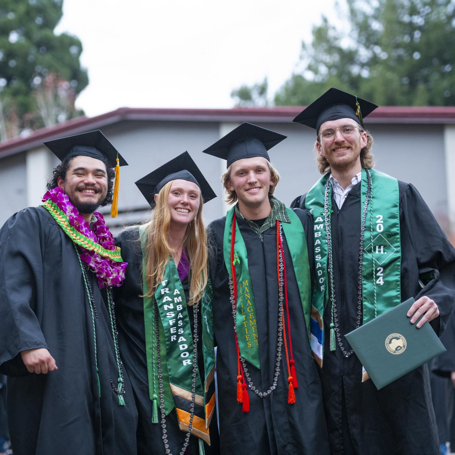 4 transfer students in their graduation regalia. 