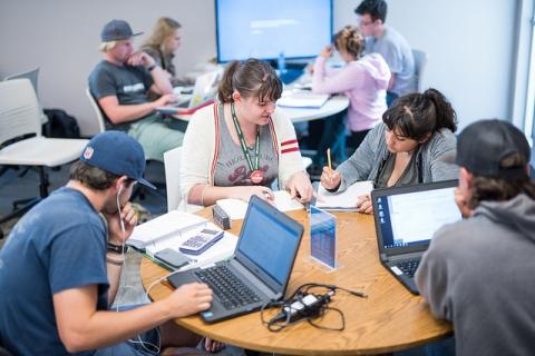 Students sitting at a round table all studying together