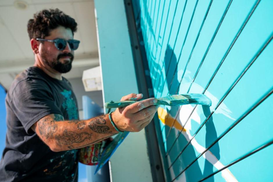A photo of artist Tony Diaz painting a mural on the Humboldt Bay Aquatic Center. A photo of artist Tony Diaz painting a mural on the Humboldt Bay Aquatic Center.
