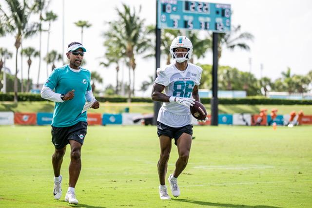 A photo of Robert Prince (left) training and coaching a team member of the NFL's Miami Dolphins on a practice field. A photo of Robert Prince (left) training and coaching a team member of the NFL's Miami Dolphins on a practice field.