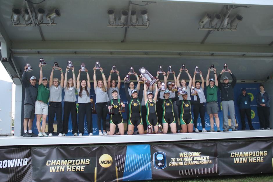 team on stage holding up their trophies 